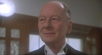 Movie still from “Murder on the Orient Express” (1974), directed by Sidney Lumet – An older man in a black suit and white shirt; Close Up shot, Low angle