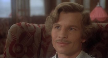 Movie still from “Murder on the Orient Express” (1974), directed by Sidney Lumet – A person sitting on a couch; Close Up shot, Low angle