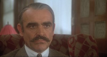 Movie still from “Murder on the Orient Express” (1974), directed by Sidney Lumet – A man with a mustache sitting on a chair; Close Up shot, Low angle
