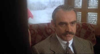 Movie still from “Murder on the Orient Express” (1974), directed by Sidney Lumet – A man in a suit and tie; Close Up shot, Over the shoulder angle