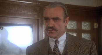 Movie still from “Murder on the Orient Express” (1974), directed by Sidney Lumet – An older man with a mustache wearing a suit and tie; Close Up shot, Low angle