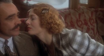 Movie still from “Murder on the Orient Express” (1974), directed by Sidney Lumet – A woman sitting on a couch with her eyes closed; Close Up shot, Over the shoulder angle