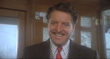 Movie still from “Murder on the Orient Express” (1974), directed by Sidney Lumet – A person wearing a suit and tie; Close Up shot, Low angle