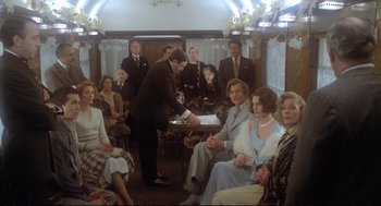 Movie still from “Murder on the Orient Express” (1974), directed by Sidney Lumet – A group of people sitting on a train; Wide shot, High angle
