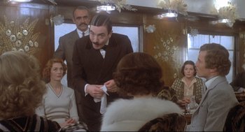 Movie still from “Murder on the Orient Express” (1974), directed by Sidney Lumet – A group of people sitting in a room; Medium shot, Over the shoulder angle