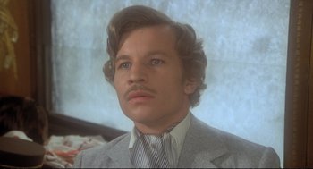 Movie still from “Murder on the Orient Express” (1974), directed by Sidney Lumet – A person wearing a suit and tie; Close Up shot, Low angle
