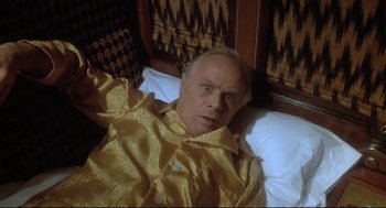 Movie still from “Murder on the Orient Express” (1974), directed by Sidney Lumet – An older man in a yellow shirt laying in a bed; Close Up shot, Overhead angle