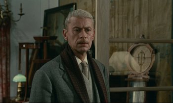 Movie still from “Muriel” (1963), directed by Alain Resnais – An older man in a suit and tie; Medium shot, Low angle