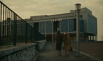 Movie still from “Muriel” (1963), directed by Alain Resnais – Two women are standing in front of a casino; Extreme Wide shot, Low angle