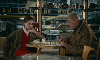 Movie still from “Muriel” (1963), directed by Alain Resnais – A man and a woman sitting at a table in a restaurant; Medium shot, High angle