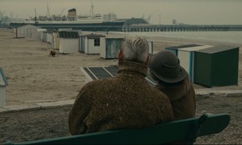 Movie still from “Muriel” (1963), directed by Alain Resnais – Two people sitting on a bench looking out at the ocean; Wide shot, Over the shoulder angle