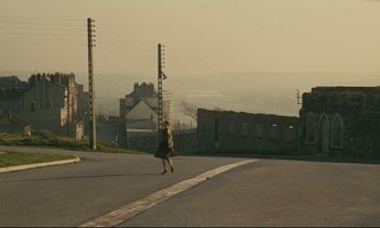 Movie still from “Muriel” (1963), directed by Alain Resnais – A woman walking down the middle of the street; Extreme Wide shot, High angle