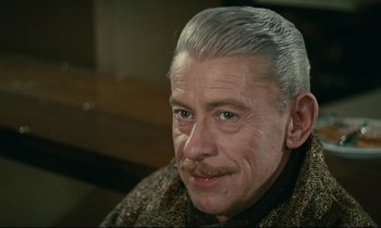 Movie still from “Muriel” (1963), directed by Alain Resnais – An older man with white hair and a mustache; Close Up shot, High angle