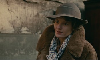 Movie still from “Muriel” (1963), directed by Alain Resnais – A woman wearing a hat and a coat; Close Up shot, Over the shoulder angle