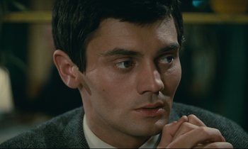 Movie still from “Muriel” (1963), directed by Alain Resnais – A person wearing a suit and tie; Close Up shot, High angle
