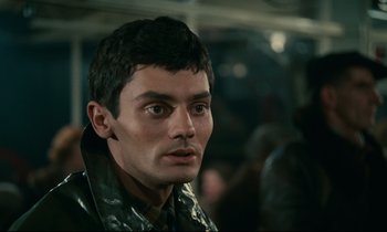 Movie still from “Muriel” (1963), directed by Alain Resnais – A person wearing a leather jacket; Close Up shot, Over the shoulder angle