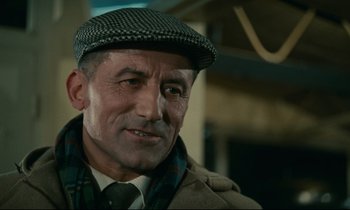 Movie still from “Muriel” (1963), directed by Alain Resnais – An older man wearing a hat and a tie; Close Up shot, Low angle