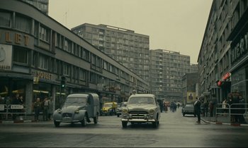 Movie still from “Muriel” (1963), directed by Alain Resnais – Cars are driving down the street in the rain; Extreme Wide shot, Low angle