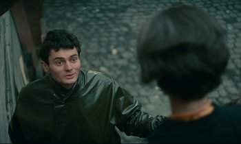 Movie still from “Muriel” (1963), directed by Alain Resnais – A man in a black jacket is talking to another man; Close Up shot, Over the shoulder angle