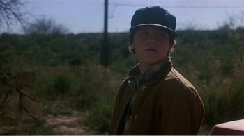 Movie still from “Murphy's Romance” (1985), directed by Martin Ritt – A young boy wearing a baseball cap and a jacket; Close Up shot, Low angle