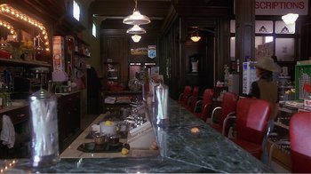 Movie still from “Murphy's Romance” (1985), directed by Martin Ritt – A bar with a lot of red chairs around it; Wide shot, High angle