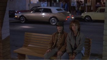 Movie still from “Murphy's Romance” (1985), directed by Martin Ritt – A couple of people sitting on top of a wooden bench; Wide shot, High angle