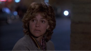 Movie still from “Murphy's Romance” (1985), directed by Martin Ritt – A person wearing a jacket with lights in the background; Close Up shot, Over the shoulder angle