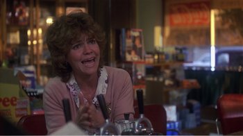 Movie still from “Murphy's Romance” (1985), directed by Martin Ritt – A woman sitting at a table with a wine glass; Close Up shot, Over the shoulder angle
