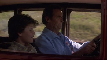 Movie still from “Murphy's Romance” (1985), directed by Martin Ritt – A man and a boy are driving a car together; Medium shot, Low angle