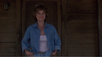 Movie still from “Murphy's Romance” (1985), directed by Martin Ritt – A woman standing in front of a wooden door; Medium shot, Low angle