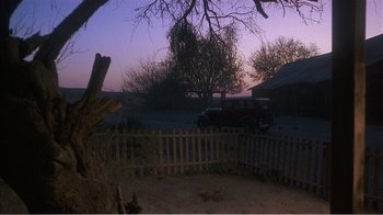 Movie still from “Murphy's Romance” (1985), directed by Martin Ritt – An old car parked in a fenced in yard; Extreme Wide shot, High angle