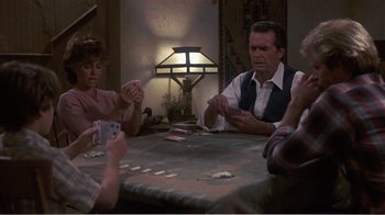Movie still from “Murphy's Romance” (1985), directed by Martin Ritt – A group of people sitting around a table playing cards; Medium shot, Over the shoulder angle