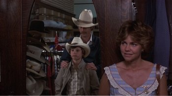 Movie still from “Murphy's Romance” (1985), directed by Martin Ritt – A man and a woman standing next to a boy in a cowboy hat; Medium shot, Over the shoulder angle