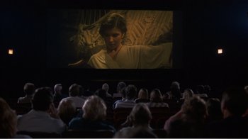 Movie still from “Murphy's Romance” (1985), directed by Martin Ritt – People are sitting in a theater watching a movie; Wide shot, High angle
