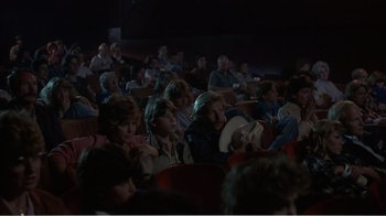 Movie still from “Murphy's Romance” (1985), directed by Martin Ritt – A group of people sitting in a theater watching a show; Wide shot, High angle
