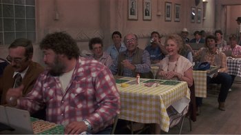 Movie still from “Murphy's Romance” (1985), directed by Martin Ritt – A group of people sitting around a table; Medium shot, Over the shoulder angle