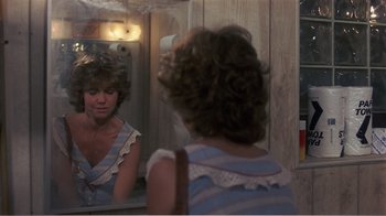 Movie still from “Murphy's Romance” (1985), directed by Martin Ritt – A woman looking in the mirror in front of a mirror; Medium shot, Over the shoulder angle