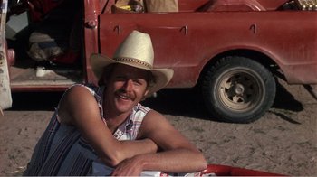 Movie still from “Murphy's Romance” (1985), directed by Martin Ritt – A man in a cowboy hat sitting next to a red truck; Medium shot, Low angle