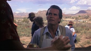 Movie still from “Murphy's Romance” (1985), directed by Martin Ritt – A man in an apron is holding a jar; Close Up shot, Over the shoulder angle