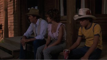 Movie still from “Murphy's Romance” (1985), directed by Martin Ritt – A group of people sitting next to each other on a bench; Medium shot, High angle