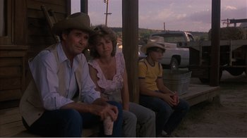 Movie still from “Murphy's Romance” (1985), directed by Martin Ritt – A man , woman , and a young boy sitting on a porch; Medium shot, Over the shoulder angle