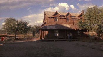 Movie still from “Murphy's Romance” (1985), directed by Martin Ritt – Two people standing in front of a wooden house; Extreme Wide shot, Low angle