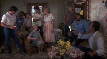 Movie still from “Murphy's Romance” (1985), directed by Martin Ritt – A group of people gathered in a living room; Wide shot, High angle