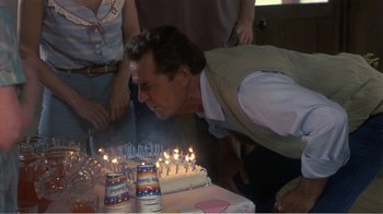 Movie still from “Murphy's Romance” (1985), directed by Martin Ritt – A man blowing out candles on a birthday cake; Close Up shot, Over the shoulder angle