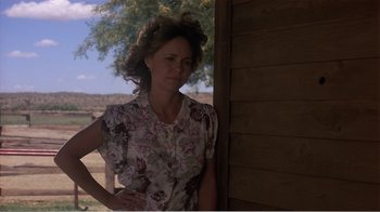 Movie still from “Murphy's Romance” (1985), directed by Martin Ritt – A woman standing in front of a wooden wall; Medium shot, Over the shoulder angle