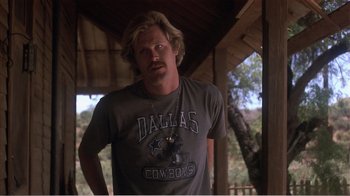 Movie still from “Murphy's Romance” (1985), directed by Martin Ritt – A man standing in front of a wooden structure; Medium shot, Low angle
