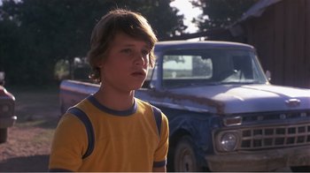 Movie still from “Murphy's Romance” (1985), directed by Martin Ritt – A young boy standing in front of an old truck; Close Up shot, Low angle