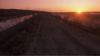 Movie still from “Murphy's Romance” (1985), directed by Martin Ritt – The sun is setting over a dirt road; Extreme Wide shot, High angle