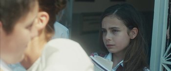 Movie still from “Mustang” (2015), directed by Deniz Gamze Ergüven – A young girl is holding a book in her hands; Close Up shot, Over the shoulder angle