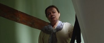 Movie still from “Mustang” (2015), directed by Deniz Gamze Ergüven – A woman wearing a neck scarf standing next to a wall; Medium shot, Low angle